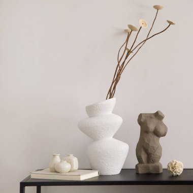 Fotokopi alanı, bej duvar, kurutulmuş çiçekli beyaz vazo, heykel ve şık aksesuarlarla minimalist iç mekan kompozisyonu. Ev dekoru. Şablon. 