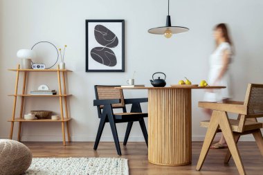 Estetik ve zarif bir odanın iç tasarımı, kadın elbiseleri, poster çerçevesi, yuvarlak masa, sebze, rattan sandalye ve kişisel aksesuarlar. Şık bir ev dekoru. Şablon.