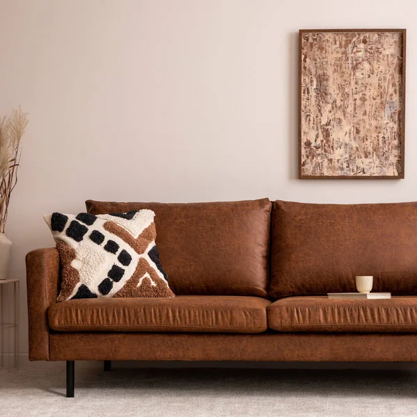 Oturma odasının içi sıcacık, poster şöhreti, kahverengi kanepe, bej halı, desenli yastık, modern pouf, kurumuş çiçekli vazo, dekorasyon ve kişisel aksesuarlarla dolu. Sıcak ev dekorasyonu. Şablon.