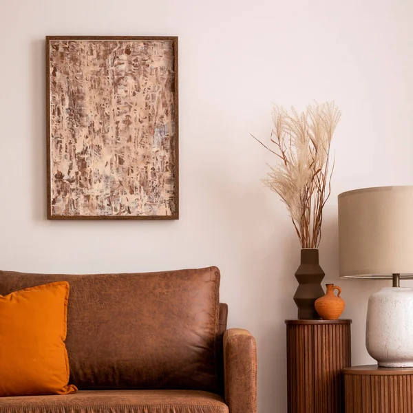 客厅内部的现代构图 有模拟的招贴画框架 褐色沙发 米黄色地毯 木制灯台和有钻孔花的花瓶 橙色枕头和个人饰物 家居装饰 — 图库照片