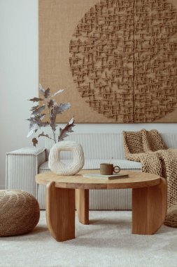 Aesthetic composition of living room interior with mock up poster,  modular beige sofa, round coffee table, rug, pouf, bowl, vase with rowan, books and personal accessories. Home decor. Template.