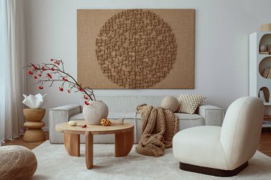 Creative composition of living room interior with mock up poster frame, beige sofa, wooden coffee table, rounded shapes armchair, vase with rowanberry and personal accessories. Home decor. Template.