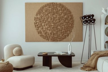 Creative composition of japandi  living room interior with mock up poster frame, black coffee table, rounded shapes armchair, brown pouf, stylish lamp and personal accessories. Home decor. Template.
