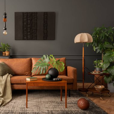 Interior design of living room interior with mock up poster frame, brown sofa, plants, wooden coffee table, lamp, ball, stylish rug, plaid, pillows and personal accessories. Home decor. Template. 