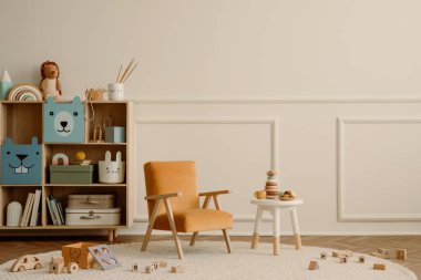 Fotokopi alanı, turuncu koltuk, ahşap büfe, yuvarlak tabure, bej halı pelüşlü oyuncaklar, ahşap bloklayıcılar ve kişisel aksesuarlarla çocuk odasının minimalist kompozisyonu. Ev dekoru. Şablon.