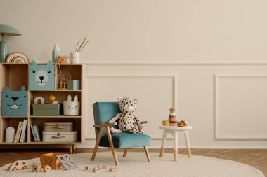Fotokopi alanı, mavi koltuk, ahşap büfe, bej halı, peluş oyuncaklar, ahşap bloklayıcılar, sıva ve kişisel aksesuarlarla dolu duvarlı çocuk odasının minimalist kompozisyonu. Ev dekoru. Şablon.
