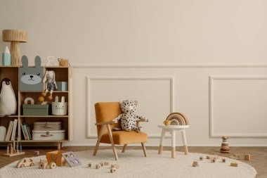 Fotokopi alanı, turuncu koltuk, ahşap büfe, yuvarlak tabure, bej halı pelüşlü oyuncaklar, ahşap bloklayıcılar ve kişisel aksesuarlarla çocuk odasının minimalist kompozisyonu. Ev dekoru. Şablon.