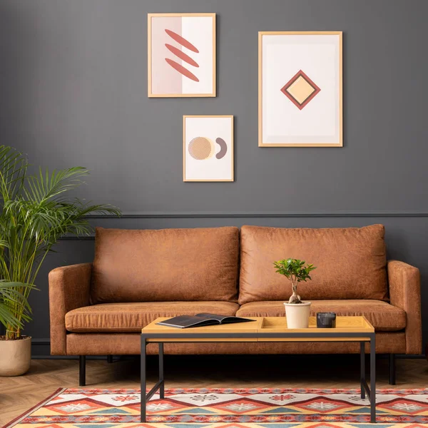 stock image Modern living room interior with mock up poster frame, brown sofa, wooden coffee table, patterned rug,  round clock, plants, beige curtain, desk and personal accessories. Home decor. Template. 