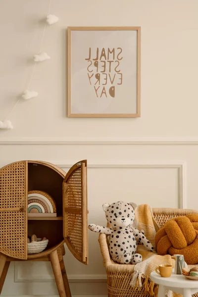 舒适的儿童房间的内部 与模拟海报框架 毛绒玩具 橙色枕头 编织扶手椅 藤条餐具柜 云彩花环 米色墙壁与填料和个人配件 家居装饰 — 图库照片