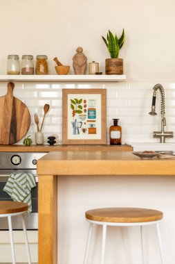 Yemek odasının iç tasarımı poster çerçevesi, ahşap mutfak adası, gümüş musluk, bitki, duvarda beyaz fayanslar, yuvarlak kesim tahtası ve mutfak aksesuarları. Ev dekoru. Şablon. 