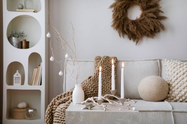 Kadife kanepe, beyaz raf, Noel giysisi, dekorasyon, hediyeler ve aksesuarlarla ev içi ve rahat bir oturma odası. Ev dekoru. Aile zamanı. Şablon.