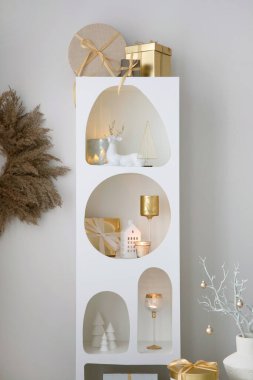 Noel süslemeleri, ışıkları, hediyeleri, fenerleri, geyikleri, mumları, yıldızları ve aksesuarları olan beyaz tasarım rafında güzel bir kompozisyon. Noel Baba geliyor. Şablon.