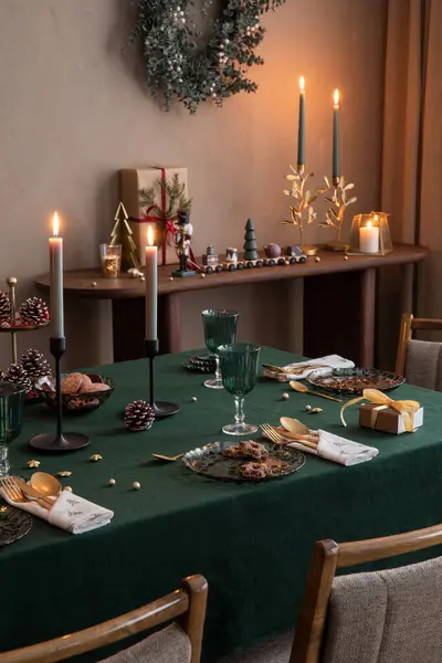 テーブル クリスマスツリー スタイリッシュな椅子 リース キャンドルスティック付きキャンドル 木製コンソール パーソナルアクセサリー付きのクリスマスダイニングルームインテリアのインテリアデザイン ホームデコレーション テンプレート ストックフォト