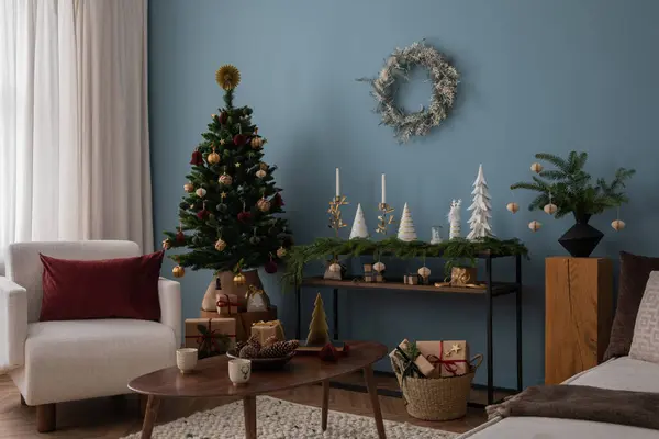 美しい装飾 白いアームチェア クリスマスツリー ボール コンソール リース キャンドル スター ギフト 光とエレガントなアクセサリーでリビングルーム内装のクリスマス構成 ストック画像