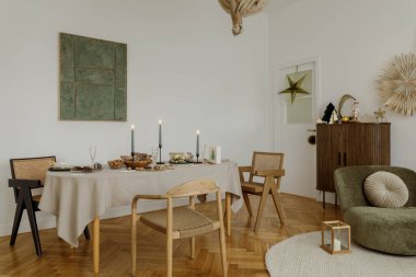 Zarif bir tatil yemek odası. Mumlarla, doğal elementlerle ve şık sandalyelerle modern bir yemek düzeni. Noel toplantıları için mükemmel..