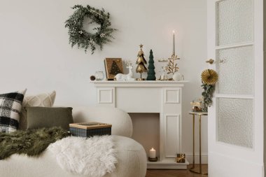 Hassas süsler, yıldızlar ve sıcak ışıklandırmanın yer aldığı minimalist bir Noel düzeneği. Modern bir tatil geleneği..