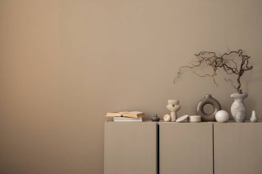 Sıcak ve rahat oturma odasının minimalist kompozisyonu fotokopi alanı, kahverengi büfe, dallı gri vazo, kitaplar, tabut, şık heykel ve kişisel aksesuarlar. Ev dekoru. Şablon.