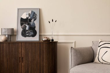 Poster çerçevesi, gri kanepe, desenli yastık, sıva ve kişisel aksesuarlarla kaplı duvar ile oturma odasının sıcak ve rahat kompozisyonu. Ev dekoru. Şablon. 