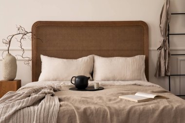 Yatak odasının yaratıcı kompozisyonu rahat yatak odası, bej yatak, ekose, sürahi ve fincanlı eser, dallı kahve masası, siyah merdiven ve kişisel aksesuarlarla. Ev dekoru. Şablon. 