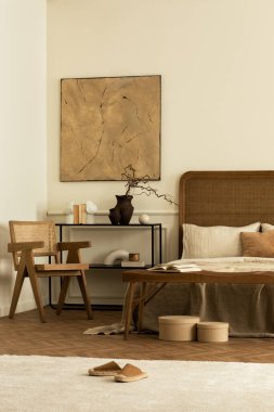 Yatak odasının yaratıcı kompozisyonu poster çerçevesi, rahat yatak, bej yatak, rattan koltuk, siyah raf, parlak halı, dallı ve kişisel aksesuarlı vazo. Ev dekoru. Şablon.