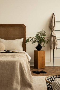 Yatak odasının iç dekorasyonu, rahat yatak odası, bej yatak, ahşap komodin, yapraklı vazo, terlik, siyah merdiven, parlak halı ve kişisel aksesuarlar. Ev dekorasyonu. Şablon.