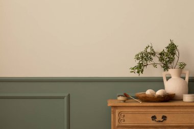 Oturma odasının minimalist kompozisyonu fotokopi alanı, alçılı yeşil duvar, ahşap büfe, yapraklı bej vazo, kase ve kişisel aksesuarlar. Ev dekoru. Şablon.