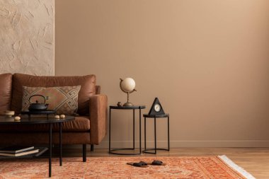 Oturma odasının minimalist kompozisyonu fotokopi alanı, kahverengi kanepe, desenli halı, terlik, siyah sehpa ve kişisel aksesuarlar. Ev dekoru. Şablon. 