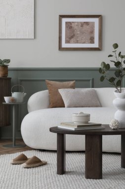 Konforlu bir iç mekan kompozisyonu poster çerçevesi, Boucle kanepesi, ahşap sehpa, yastıklar, beyaz terlikler, şık heykeller ve kişisel aksesuarlar. Ev dekoru. Şablon.