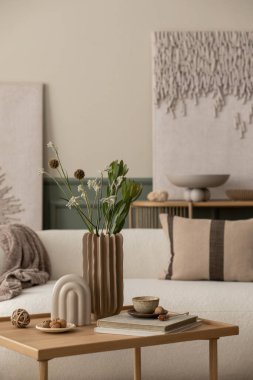 Baharın oturma odasının rahat kompozisyonu poster çerçevesi, Boucle kanepesi, ahşap sehpa, kitaplar, şık heykel, yapraklı vazo ve kişisel aksesuarlar. Ev dekoru. Şablon. 