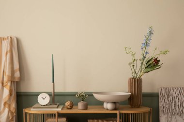 Yay oturma odasının minimalist kompozisyonu ahşap büfe, şık kase, renkli çiçekli vazo, şamdanlı mum ve kişisel aksesuarlarla. Ev dekoru. Şablon. 