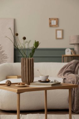 Baharın oturma odasının rahat kompozisyonu poster çerçevesi, Boucle kanepesi, ahşap sehpa, kitaplar, şık heykel, yapraklı vazo ve kişisel aksesuarlar. Ev dekoru. Şablon. 