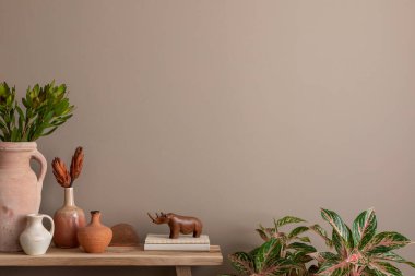 Oturma odasının minimalist kompozisyonu. İçi fotokopi alanı, ahşap konsola, saksıdaki bitkiler, kitaplar, çiçekli vazo, heykel ve kişisel aksesuarlarla dolu. Ev dekoru. Şablon.