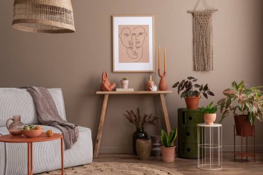 Oturma odasının yaratıcı kompozisyonu poster çerçevesi, ahşap consola, yuvarlak kahve masası, bej kanepe, bitkiler, terasota yastığı ve kişisel aksesuarlar. Ev dekoru. Şablon.