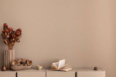 Oturma odasının minimalist kompozisyonu fotokopi alanı, basit bej büfe, kurutulmuş çiçekli vazo, kitaplar ve kişisel aksesuarlar. Ev dekoru. Şablon. 