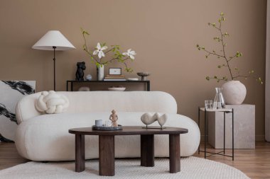 Oturma odasının yaratıcı kompozisyonu poster çerçevesi, boucle kanepesi, ahşap sehpa, yuvarlak halı, beyaz koltuk, manolya ve kişisel aksesuarlar. Ev dekoru. Şablon.