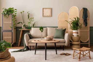 Baharın iç dekorasyonu poster çerçevesi, bej kanepe, ahşap sehpa, saksıda bitkiler, rattan büfe ve kişisel aksesuarlar. Ev dekoru. Şablon.