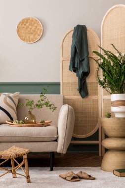 Bej kanepe, halı, ahşap konsol, bölme duvarı, saksıda bitkiler, yapraklı vazolar ve kişisel aksesuarlarla botanik oturma odasının yaratıcı kompozisyonu. Ev dekoru. Şablon.