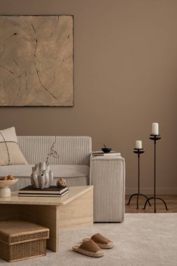 Oturma odasının minimalist kompozisyonu poster çerçevesi, bej kanepe, travertin sehpa, örgülü sepet, siyah şamdan ve kişisel aksesuarlar. Ev dekoru. Şablon.