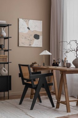 Poster çerçevesi, ahşap masa, ahşap sandalye, şık lamba, siyah raf, kitaplar ve ofis aksesuarları ile sıcak ve rahat ofis içerikli yaratıcı bir kompozisyon. Ev dekoru. Şablon. 