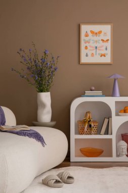 Sıcak ve rahat bir oturma odası. Poster çerçevesi, çiçek desenli kanepe, modern beyaz büfe, şık bir halı, çiçekli vazo, renkli süsler ve kişisel aksesuarlar. Ev dekoru. Şablon.