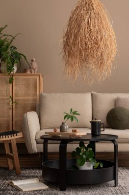 Sıcak ve rahat oturma odasının iç tasarımı bej kanepe, yuvarlak kahve masası, rattan büfe, boho lambası, gri halı, bitkiler, kitaplar ve kişisel aksesuarlarla. Ev dekoru. Şablon. 