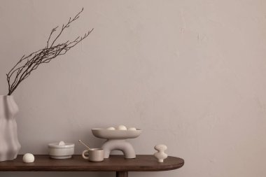 Minimalist kompozisyonu sıcak ve rahat oturma odası içinde fotokopi alanı, ahşap konsol, dallı, fincanlı, heykeltraşlı, kase ve kişisel aksesuarları olan şık vazo. Ev dekoru. Şablon.