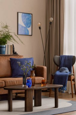 Oturma odasının sıcak ve rahat kompozisyonu poster çerçevesi, kahverengi kanepe, ahşap sehpa, desenli halı, mavi palet, yastık ve kişisel aksesuarlar. Ev dekoru. Şablon.