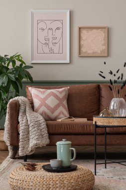 Konforlu oturma odasının iç tasarımı poster çerçevesi, kahverengi kanepe, örgülü puf, yeşil sürahi, cam vazo, desenli yastık, bitki ve kişisel aksesuarlar. Ev dekoru. Şablon.