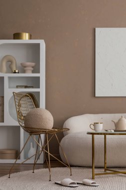 Ilık oturma odasının zarif kompozisyonu poster çerçevesi, boucle kanepesi, mermer konsol, şık yastık, kurumuş çiçekler ve kişisel aksesuarlarla süslenmiş altın vazo. Ev dekoru. Şablon.