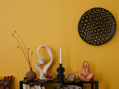 Siyah konsollu sarı oturma odasının yaratıcı kompozisyonu, şık heykel, kurumuş çiçekli vazo, renkli sepet, yastık ve kişisel aksesuarlar. Ev dekoru. Şablon