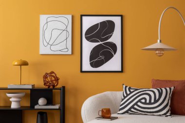 Sıcak oturma odasının içini kaplayan kompozisyonu poster çerçevesi, boucle kanepesi, desenli yastıklar, lamba, siyah askı, sarı duvar, kitaplar ve kişisel aksesuarlar. Ev dekoru. Şablon. 