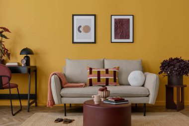 Sıcak ve rahat bir oturma odası. Poster çerçevesi, bej kanepe, siyah masa, burgund sehpa, sandalye, şık bir lamba, çiçekli vazo, halı ve kişisel aksesuarlar. Ev dekoru. Şablon.