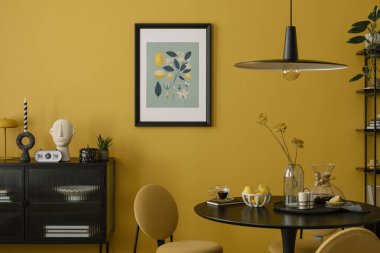 Yemek odasının sıcak ve rahat kompozisyonu poster çerçevesi, yuvarlak masa, sarı duvar, siyah büfe, kurumuş çiçekler ve kişisel aksesuarlarla süslenmiş cam vazo. Ev dekoru. Şablon.