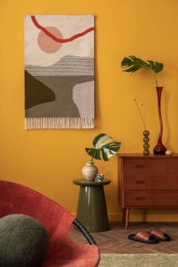 Sıcak ve rahat bir oturma odası şık kilim halısı, ahşap büfe, yeşil sehpa, terlik, kırmızı koltuk, çiçekli vazo, yeşil yastık ve kişisel aksesuarlar. Ev dekoru. Şablon.